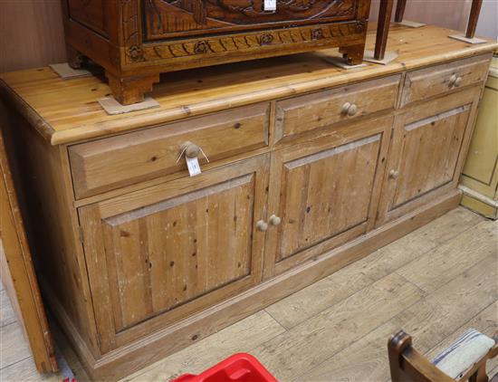 A modern pine dresser base, fitted three small drawers, over cupboard W.210cm